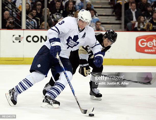 Dion Phaneuf of the Toronto Maple Leafs handles the puck around Chris Kunitz of the Pittsburgh Penguins in the overtime period at Mellon Arena on...