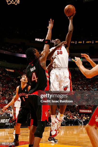 Joel Anthony of the Miami Heat shoots against Chris Bosh of the Toronto Raptors on March 28, 2010 at American Airlines Arena in Miami, Florida. NOTE...