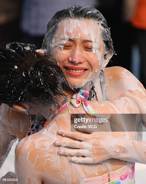 Two Chinese women wrestle in a mud pool during an international women's mud wrestling contest on March 28, 2010 in Haikou, Hainan province of China....