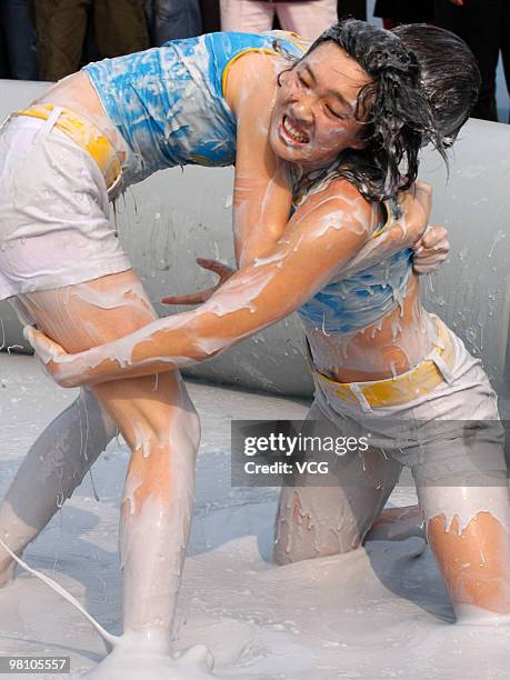 Two Chinese women wrestle in a mud pool during an international women's mud wrestling contest on March 28, 2010 in Haikou, Hainan province of China....
