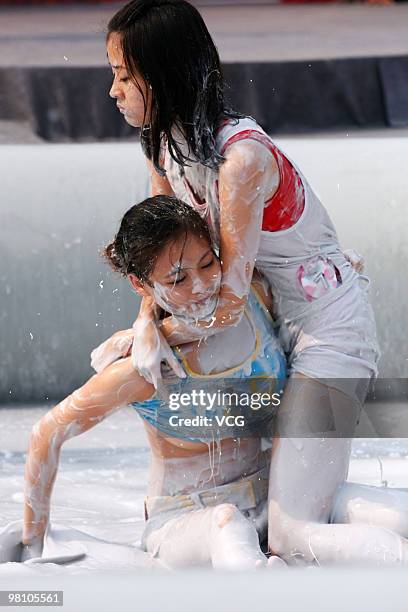 Two Chinese women wrestle in a mud pool during an international women's mud wrestling contest on March 28, 2010 in Haikou, Hainan province of China....