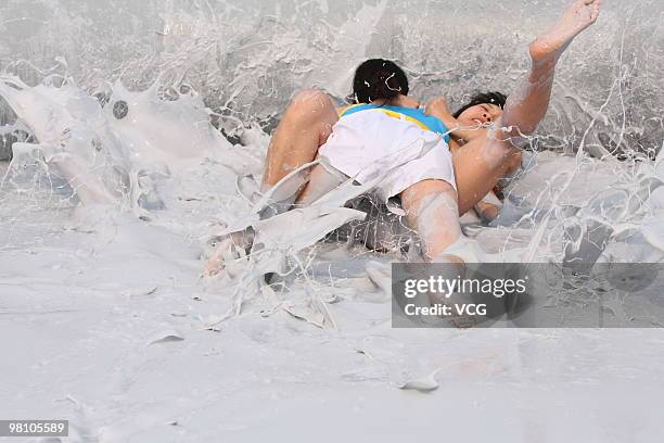 Two Chinese women wrestle in a mud pool during an international women's mud wrestling contest on March 28, 2010 in Haikou, Hainan province of China....