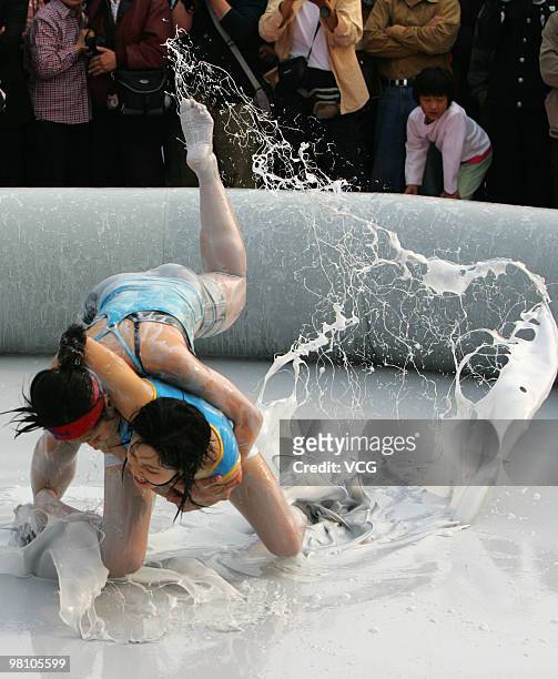 Two Chinese women wrestle in a mud pool during an international women's mud wrestling contest on March 28, 2010 in Haikou, Hainan province of China....