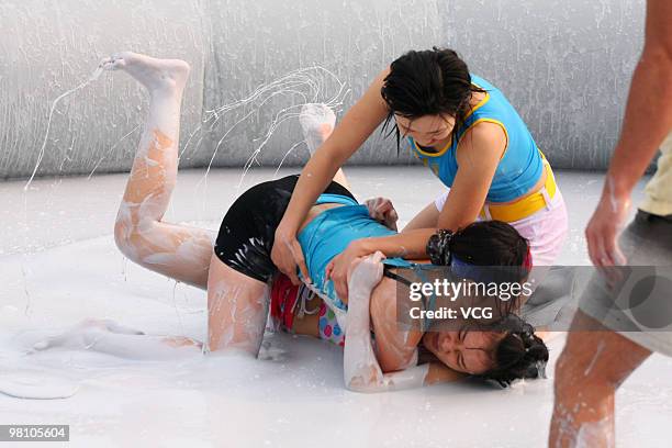 Two Chinese women wrestle in a mud pool during an international women's mud wrestling contest on March 28, 2010 in Haikou, Hainan province of China....