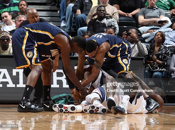 Roy Hibbert and Kareem Rush of the Indiana Pacers battle for a loose ball against Josh Smith of the Atlanta Hawks on March 28, 2010 at Philips Arena...