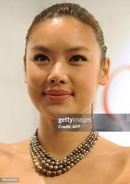 Model wears a pearl and diamond necklace with a pre-auction value of 1 000 to 2 000 US dollars during a preview at the offices of auction house...