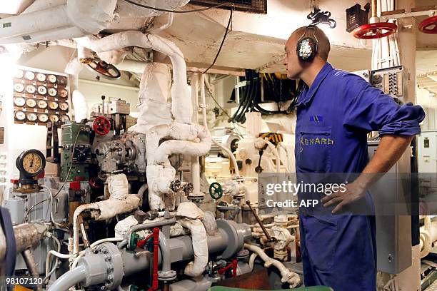 French Marine petty officer Damien Renard works in the machine room on March 22 on bard of French helicopter-carrier Jeanne d'Arc, en route from the...