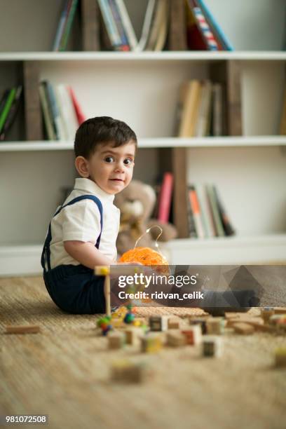 two years old child sitting on the floor with wooden cubes - estonia school stock pictures, royalty-free photos & images