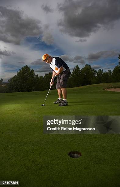 man playing golf on golf course - bent golf club stock pictures, royalty-free photos & images