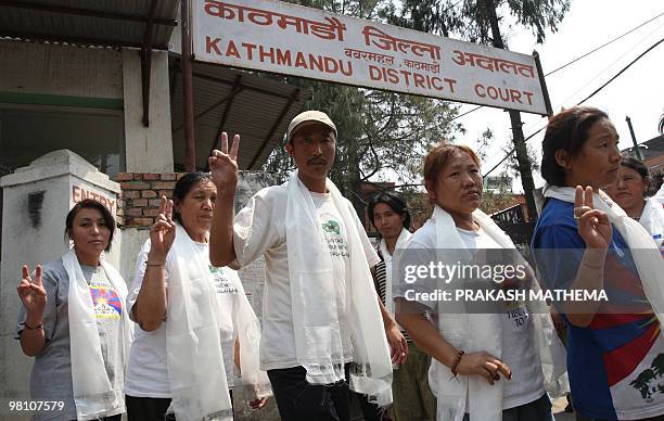 Tibetans in-exile gesture as they exit the Kathmandu District Court after their release from a jail in Kathmandu on March 29, 2010. The court ordered...