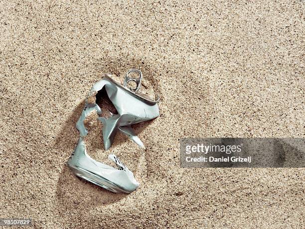 crushed tin can buried in sand - cannette photos et images de collection