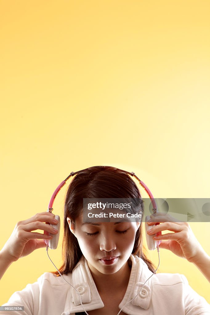 Chinese girl listening to music with headphones