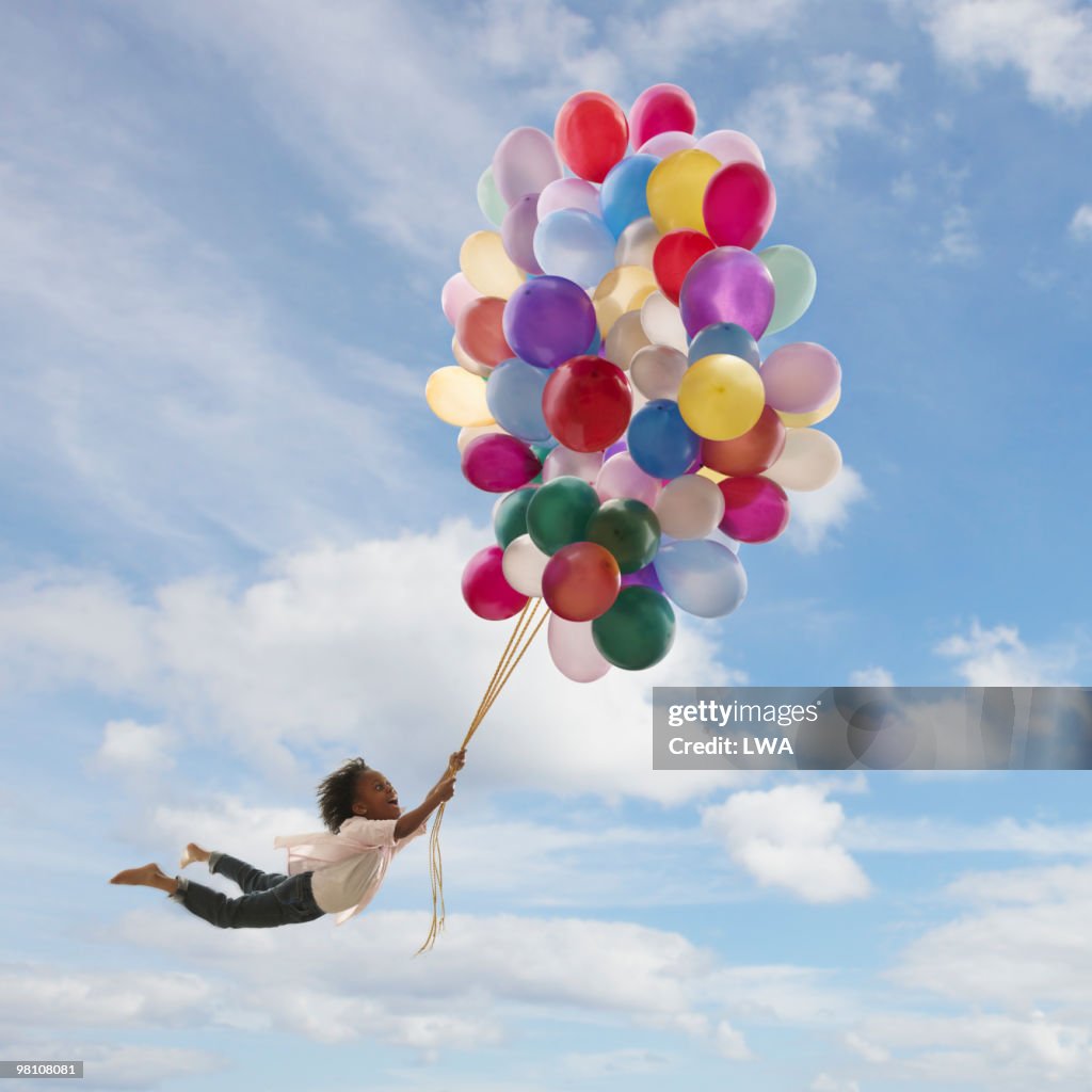 Girl Holding Onto Balloons, Floating In The Air