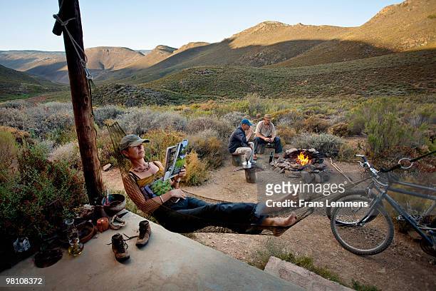 south africa, simonskloof, guests at campfire - moving down to seated position stock pictures, royalty-free photos & images