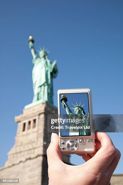 tourist taking picture of statue of liberty - travelpix stock pictures, royalty-free photos & images