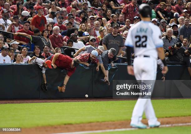 Fans attempt to grab a foul ball as Jake Lamb of the Arizona Diamondbacks looks on during a game against the New York Mets at Chase Field on June 17,...