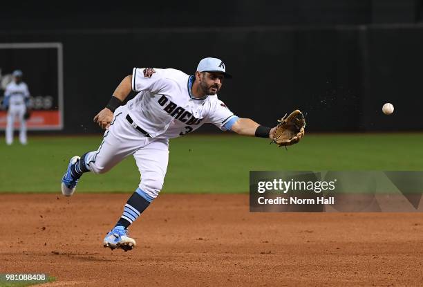 Daniel Descalso of the Arizona Diamondbacks flips the ball to first base with his glove during a game against the New York Mets at Chase Field on...