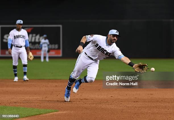 Daniel Descalso of the Arizona Diamondbacks flips the ball to first base with his glove during a game against the New York Mets at Chase Field on...