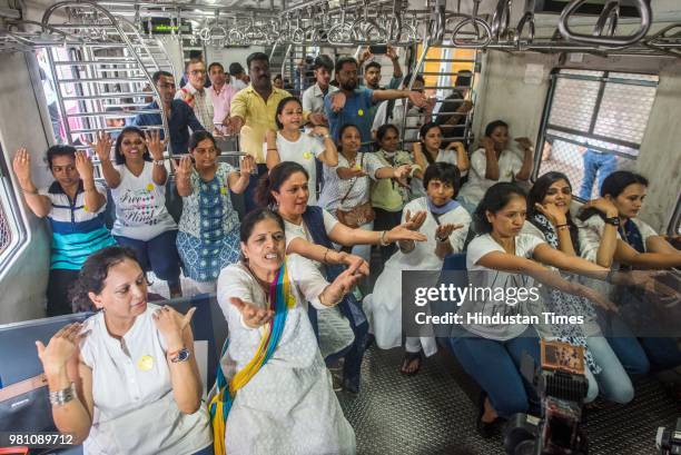 Yoga instructor along with the commuters perform yoga inside a local train on the occasion of World Yoga day, on June 21, 2018 in Mumbai, India. The...