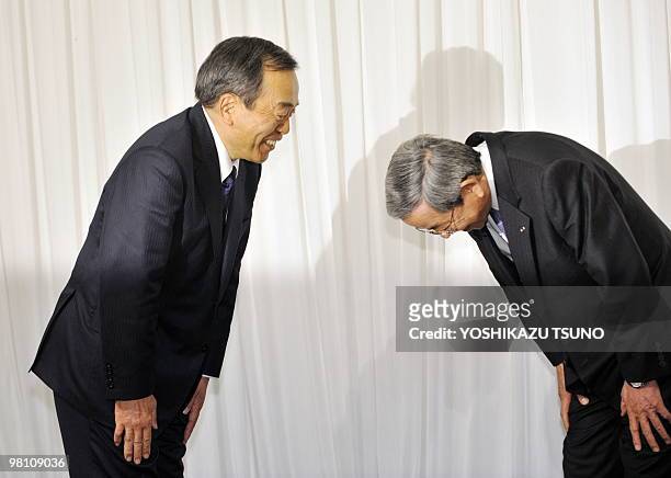 Toyota executive vice president Takeshi Uchiyamada and Mazda executive vice president Masaharu Yamaki exchage bows after they announced an agreement...