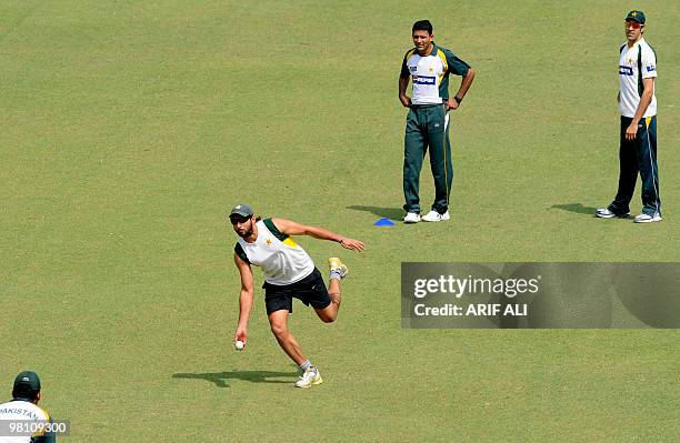 Pakistani Twenty20 cricket captain Shahid Afridi throws a ball as teammates Abdul Razzaq and Umar Gul look on during a practice session at The...