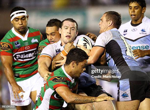 Paul Gallen of the Sharks is wrapped up by the Rabbitohs defence during the round three NRL match between the Cronulla Sharks and the South Sydney...