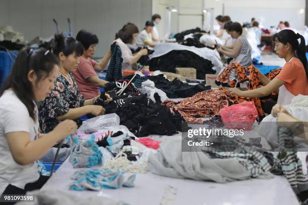 Chinese employees work on socks that will be exported at a factory in Huaibei in China's eastern Anhui province on June 22, 2018. - Beijing on June...