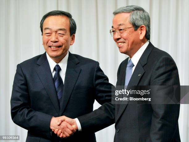 Takeshi Uchiyaimada, executive vice president of Toyota Motor Corp., left, shakes hands with Masaharu Yamaki, vice president of Mazda Motor Corp.,...