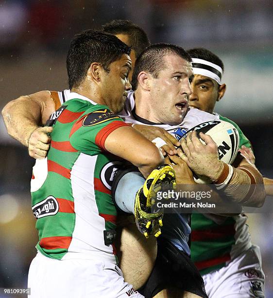 Paul Gallen of the Sharks is wrapped up by the Rabbitohs defence during the round three NRL match between the Cronulla Sharks and the South Sydney...