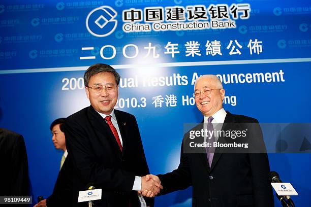 Guo Shuqing, chairman of China Construction Bank Corp., left, shakes hands with Xie Duyang, chairman of the board of supervisors, at a news...