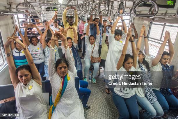 Yoga instructor along with the commuters perform yoga inside a local train on the occasion of World Yoga day, on June 21, 2018 in Mumbai, India. The...