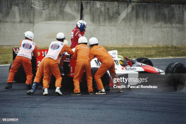 Alain Prost from France driving the Marlboro McLaren-Honda MP4/5 controversially collides with his team mate Ayrton Senna during the Japanese Grand...
