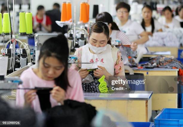 Chinese employees work on socks that will be exported at a factory in Huaibei in China's eastern Anhui province on June 22, 2018. - Beijing on June...
