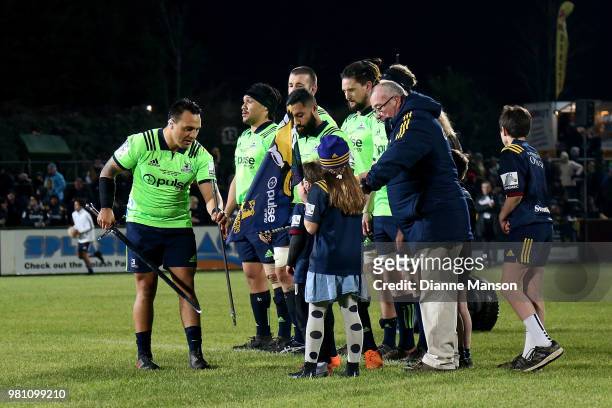 Co Captains Ash Dixon and Lima Sopoaga of the Highlanders and former All Black Leicester Rutledge, with his grandchildren, present a metal claymore...