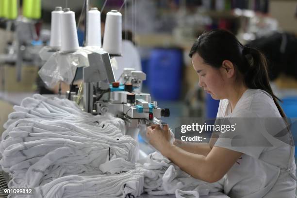 Woman works on socks that will be exported at a factory in Huaibei in China's eastern Anhui province on June 22, 2018. - Beijing on June 19 accused...