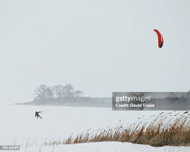 man kite boarding in a snowstorm - david trood stock-fotos und bilder