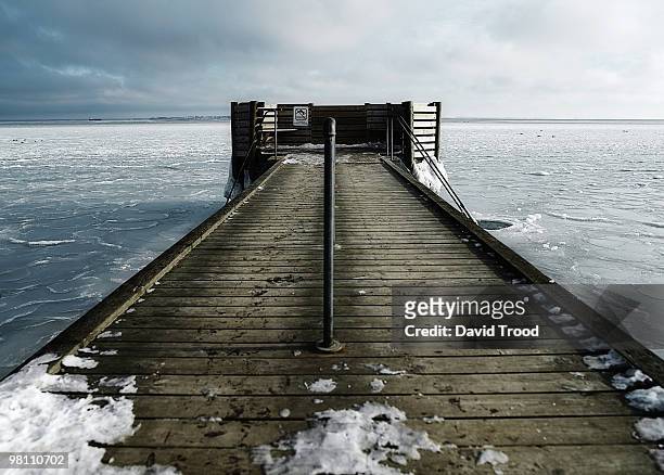 hole in the ice for winter bathing by a jetty - david trood stockfoto's en -beelden
