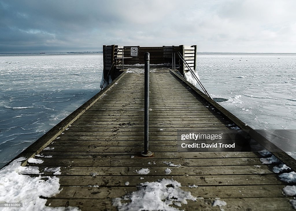Hole in the ice for winter bathing by a jetty