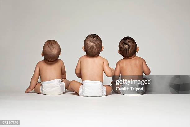 three babies in diapers looking up, rear view - de espalda fotografías e imágenes de stock