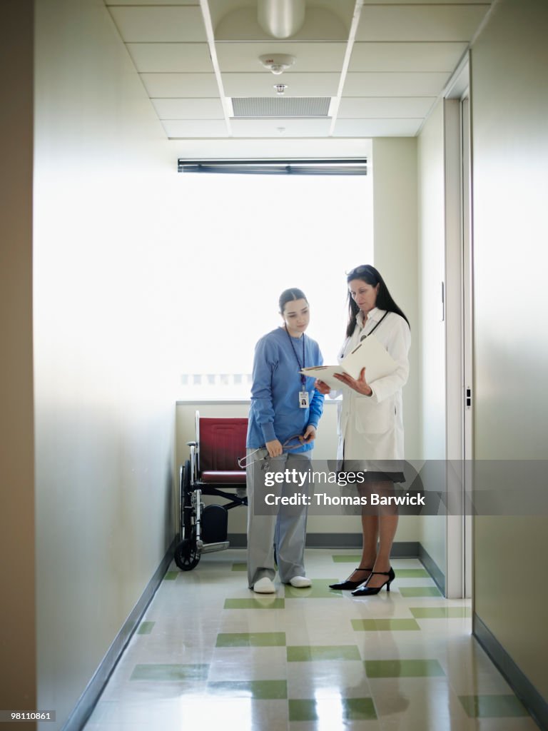 Female nurse and doctor discussing patient chart