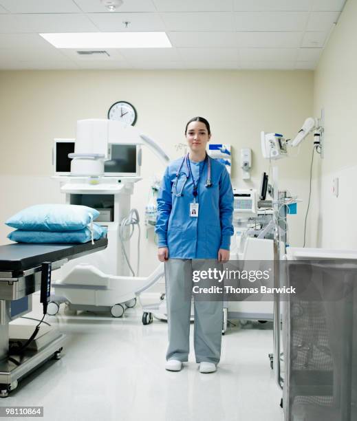 nurse standing next to x-ray machine in hospital - nurse full length stock pictures, royalty-free photos & images