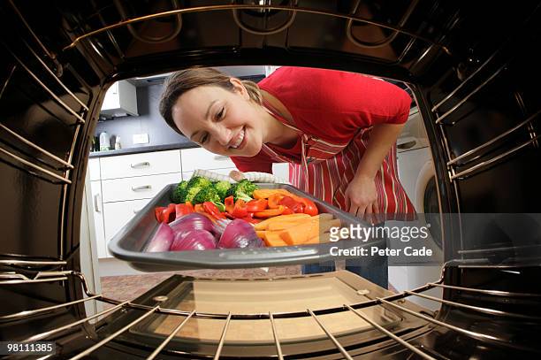 putting vegetables into oven - chicken roasting oven stock pictures, royalty-free photos & images