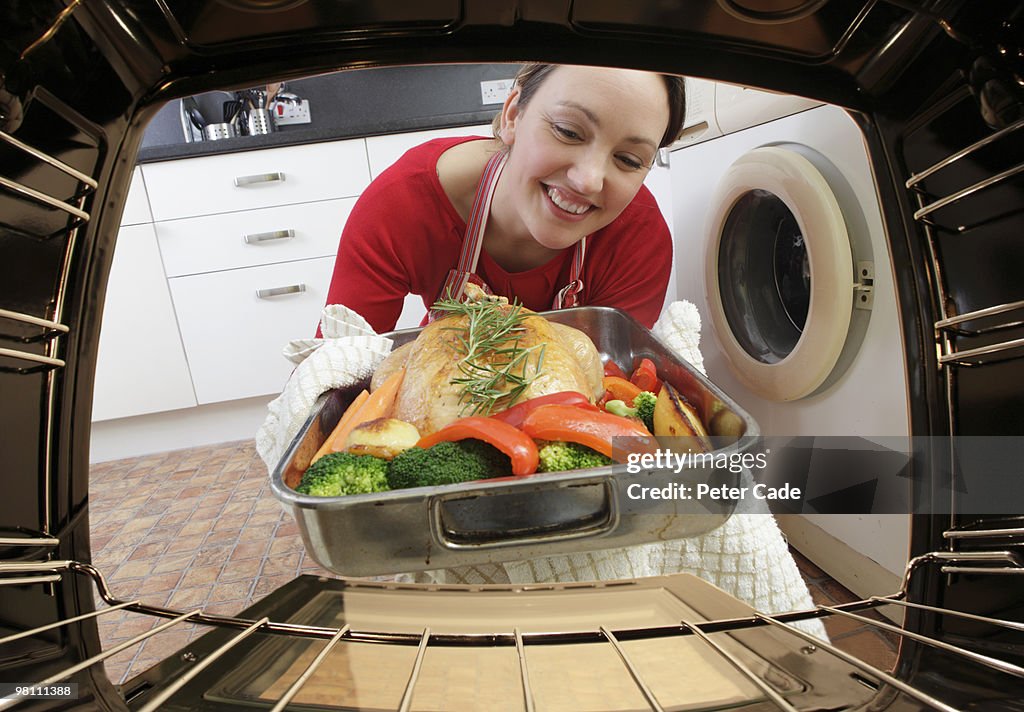 Putting chicken in oven