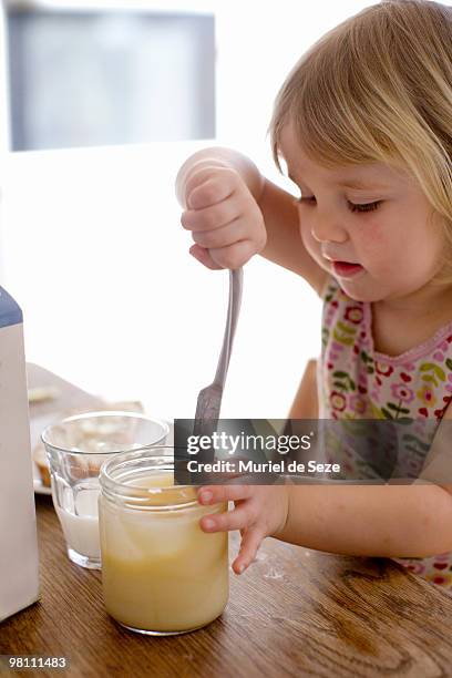 girl helping herself to honey - blonde wood texture stockfoto's en -beelden