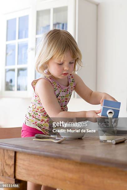 girl pouring milk in glass - cartón de bebida fotografías e imágenes de stock