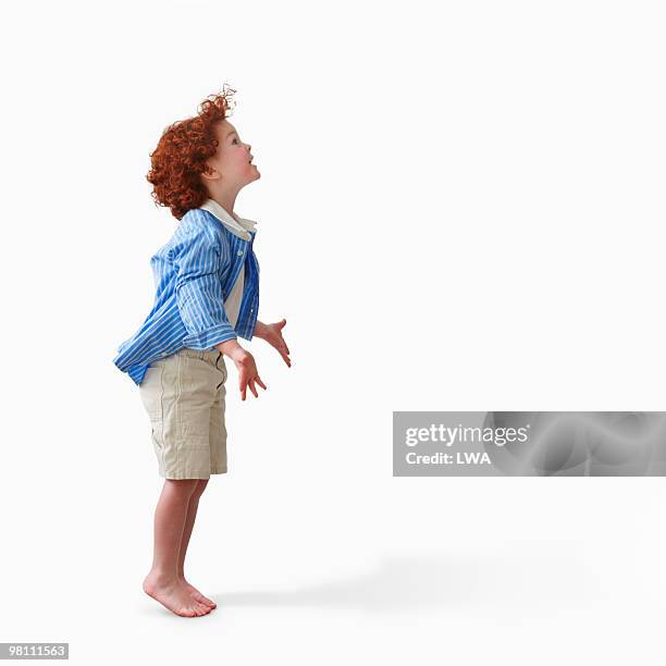 studio shot of red-headed boy, arms outstretched - barefoot redhead ストックフォトと画像