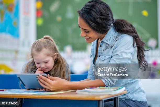 unterricht grundschule mädchen mit einem tablet - asistant stock-fotos und bilder