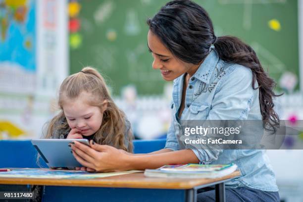 onderwijs basisschool meisje met een tablet - assistant stockfoto's en -beelden