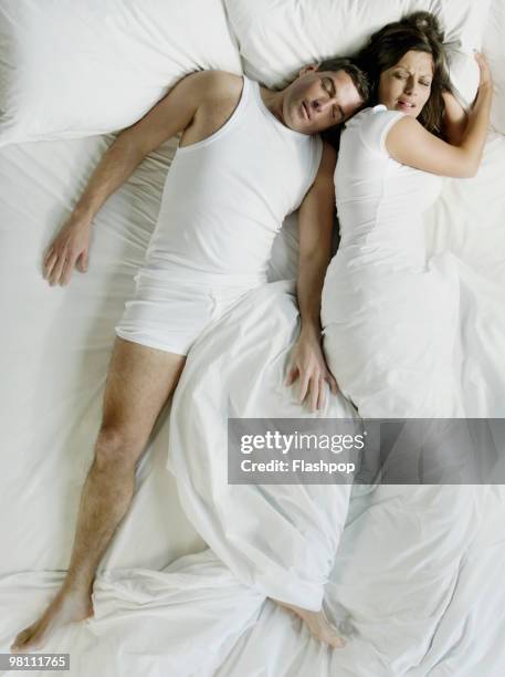 man squashing woman in bed - above view of man sleeping on bed stock pictures, royalty-free photos & images