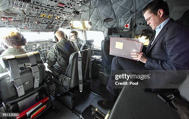 German Defense Minister Karl-Theodor zu Guttenberg reads during his flight from Berlin to Priststina on March 29, 2010. Zu Guttenberg is on a two-day...